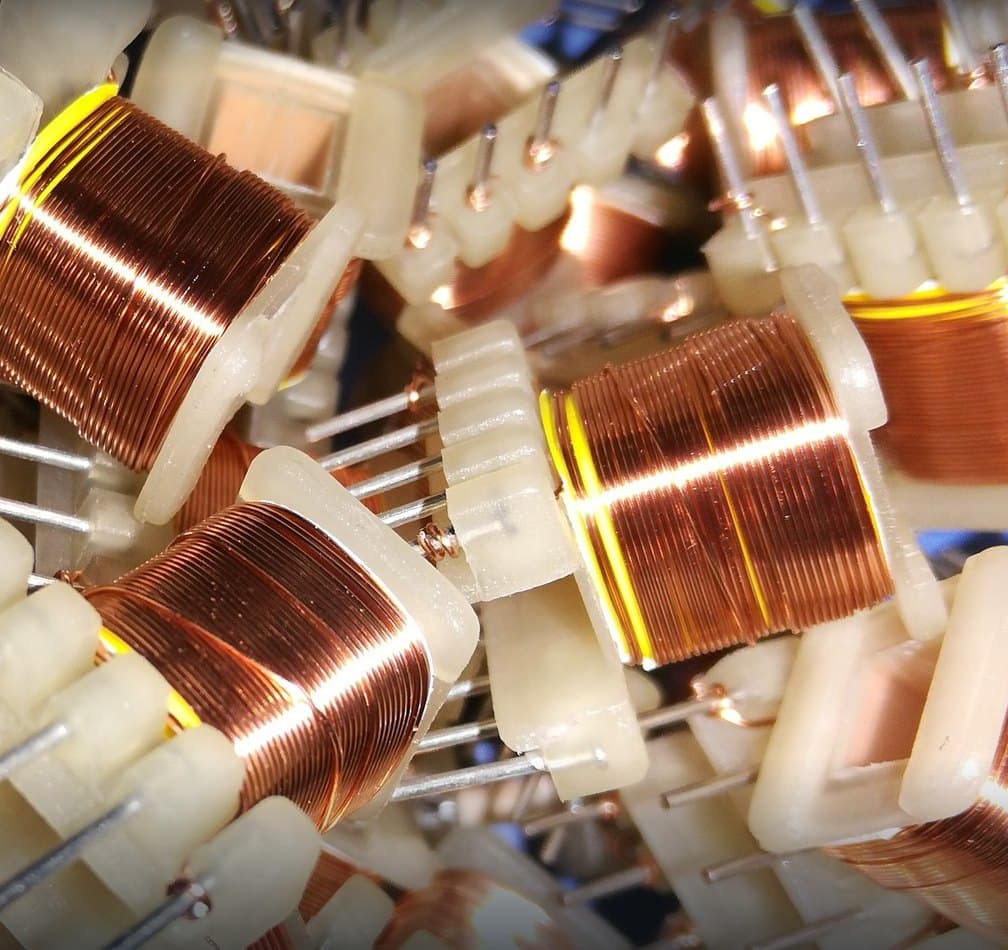 Copper-wound bobbins on the Genius Transformers winding bench